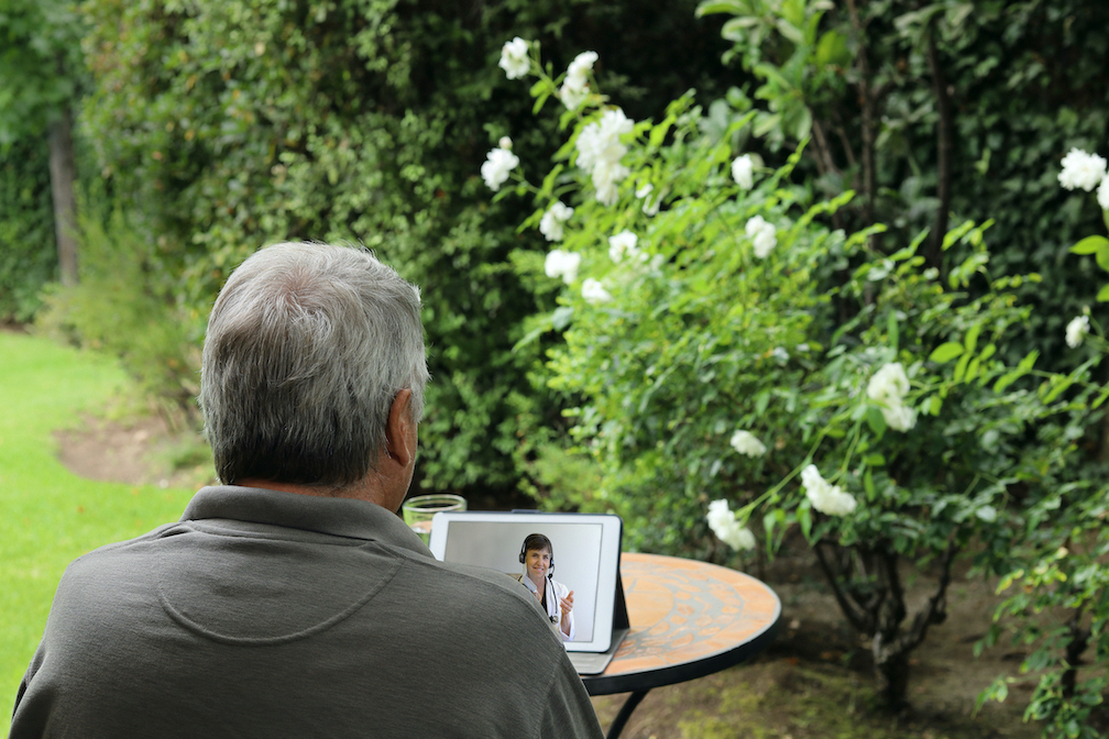 A man in the garden on a telehealth virtual call appointment.